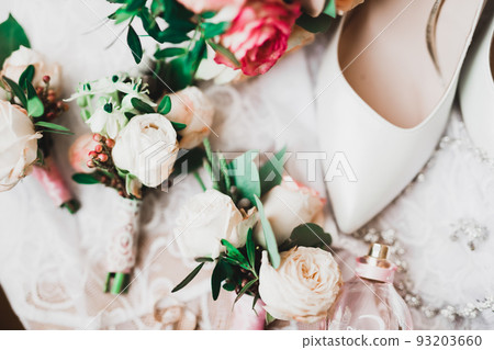 Beautiful toned picture with wedding rings against the background of a bouquet of flowers Beautiful toned picture with wedding rings against the background of a bouquet of flowers 93203660
