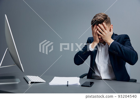a man in a suit problems at work sitting at a desk in front of a computer executive a man in a suit problems at work sitting at a desk in front of a computer executive 93204540