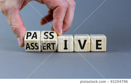 Passive or assertive symbol. Businessman turns wooden cubes and changes the word passive to assertive. Beautiful grey background, copy space. Business, psychological passive assertive concept. Passive or assertive symbol. Businessman turns wooden cubes and changes the word passive to assertive. Beautiful grey background, copy space. Business, psychological passive assertive concept. 93204796