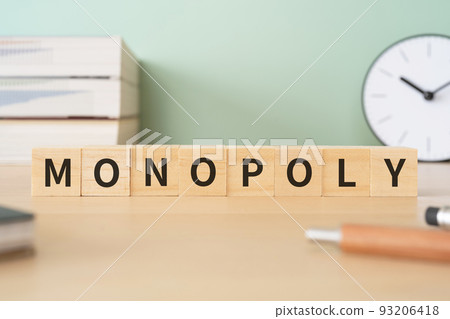 Image of monopoly/occupancy | A desk with a block written "MONOPOLY" 93206418
