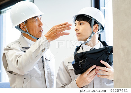Two male workers inspecting equipment 93207481