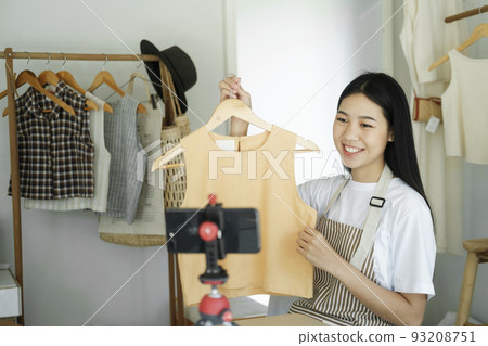 Young asian businesswoman fashion blogger showing cloth with smiling face. 93208751