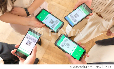 Hands of four people exchanging data with smartphones 93210343
