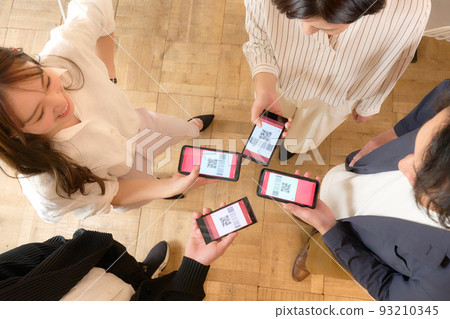 Four men and women who exchange addresses on smartphones 93210345