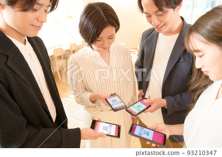 四名在智能手機上交換地址的男女 93210347