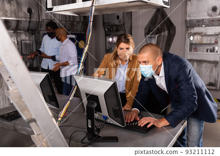 People trying to find solution of conundrum in escape room during COVID-19 pandemic 93211112