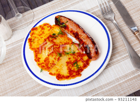 Ukrainian deruny, potato flapjacks, with fried sausage on plate 93211148
