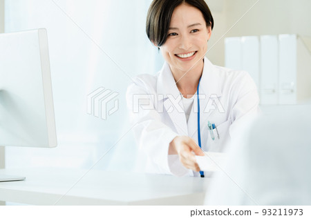 A woman in a white coat giving medicine 93211973