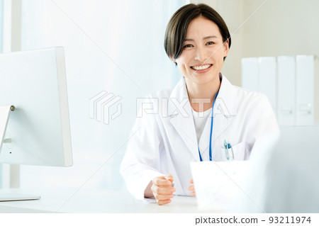 A woman in a white coat giving medicine A woman in a white coat giving medicine 93211974