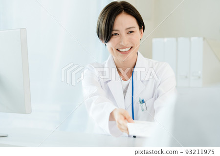 A woman in a white coat giving medicine 93211975