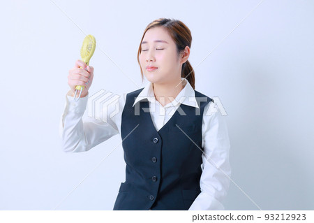 年輕的女商人用一個方便的風扇降溫 年輕的女商人用一個方便的風扇降溫 93212923