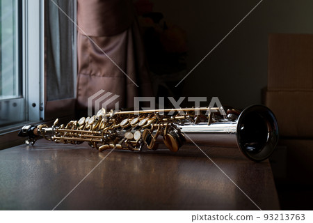 Golden Key Silver Plate Soprano Saxophone, Woodwind Instrumental Equipment on Wood Table. Golden Key Silver Plate Soprano Saxophone, Woodwind Instrumental Equipment on Wood Table. 93213763
