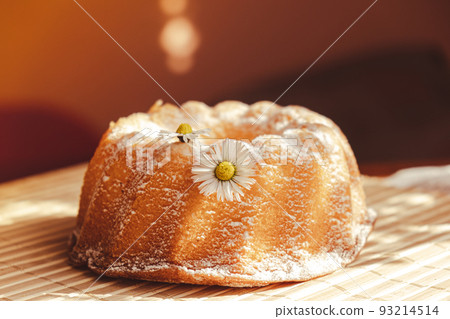 Cupcake decorated chamomile flower In the rustic style. Authentic photo. Easter concept greeting card background. Sun rays Homemade baked concept. Summer, Spring time recipe 93214514