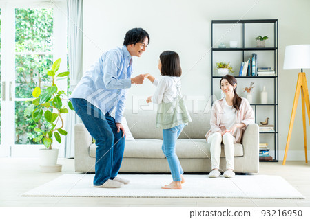 A young family of good friends hanging out in the living room 93216950