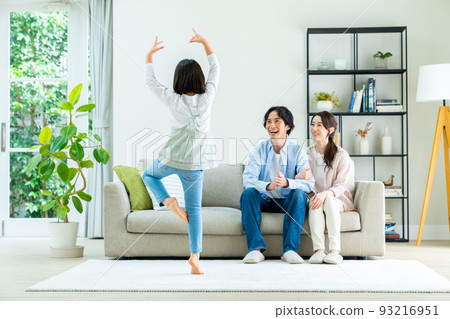 A young family of good friends hanging out in the living room 93216951