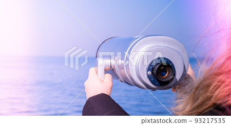 Tourist looking through coin operated binoculars. Discover new places Binocular telescope on the observation deck for tourism. Sea background. Sopot on the pier Binoculars watching at horizon at ship 93217535