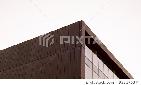 Modern office building exterior with glass facade on clear sky background. Vivid colors Transparent glass wall of office building with red pink decoration. Element of facade of modern European 93217537