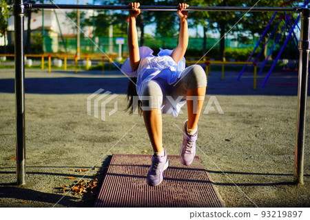 Elementary school girl playing with a horizontal bar 93219897