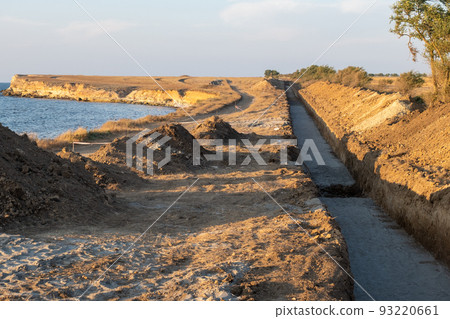 Deep trench in the ground for laying pipes. Water supply or sewerage. Construction site 93220661