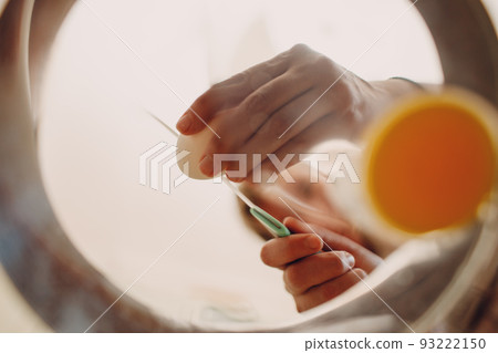 Woman makes fried eggs scrambled omelette. Cooking breakfast food. Inside bottom view. 93222150