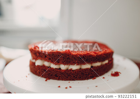 Pastry chef spreads cream and makes delicious red velvet cake. Cooking and decorating dessert. Pastry chef spreads cream and makes delicious red velvet cake. Cooking and decorating dessert. 93222151
