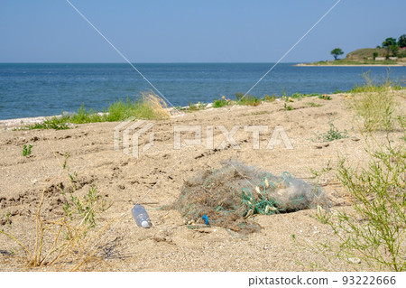 On the sand lies a tangled fishing net. The result of the activity of poachers.  On the sand lies a tangled fishing net. The result of the activity of poachers.  93222666