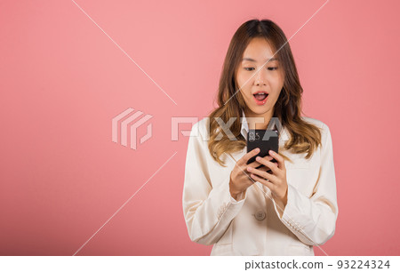 young woman teen smiling standing surprised excited wow gesture with smart mobile phone young woman teen smiling standing surprised excited wow gesture with smart mobile phone 93224324