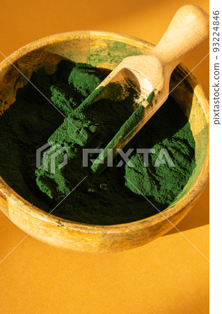 Blue-green algae Chlorella and spirulina powder in bamboo eco bowl. Super powder in spoon. Detox superfood. Natural supplement of algae 93224846