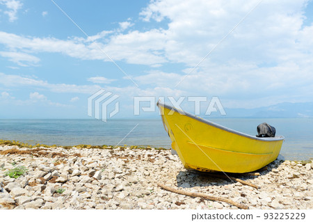 Yellow motor boat on shore of wonderful Skadar lake on the background of mountains. Amazing giant Skadar Lake is a famous bird nature reserve in Balkans located in Albania and Montenegro. 93225229