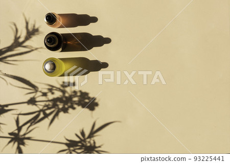 glass bottle with CBD oil, THC tincture on a pastel background with cannabis leaves shadows. minimalism. Cosmetics 93225441