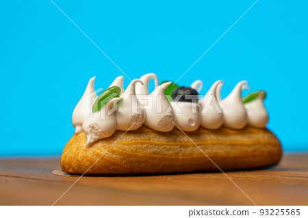 Sweet eclair on a wooden table on a blue background 93225565