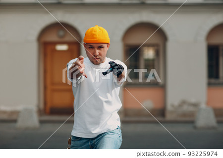 Young disabled man with artificial prosthetic hand dancing at outdoor city street 93225974