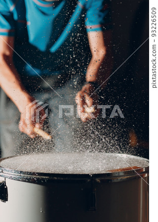 Close up drum sticks drumming hit beat rhythm on drum surface with splash water drops Close up drum sticks drumming hit beat rhythm on drum surface with splash water drops 93226509