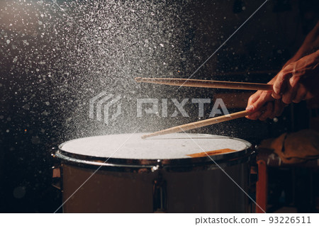 Close up drum sticks drumming hit beat rhythm on drum surface with splash water drops Close up drum sticks drumming hit beat rhythm on drum surface with splash water drops 93226511