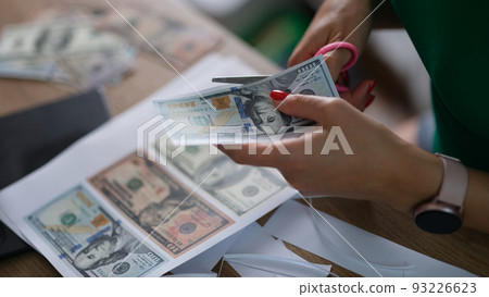 Female hand cuts counterfeit money American dollars Female hand cuts counterfeit money American dollars 93226623