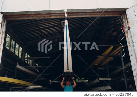 Sportsman single scull man rower prepare to competition with boat. 93227043