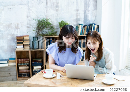 Two young women planning a trip Two young women planning a trip 93227068