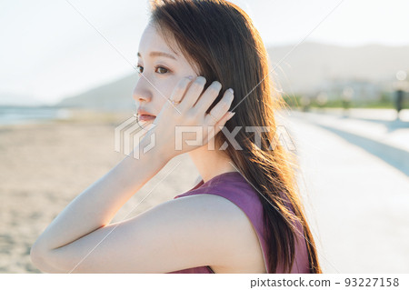 A young woman in a dress looking at the sea 93227158