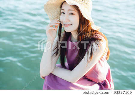 坐在海邊的草帽的年輕女人 坐在海邊的草帽的年輕女人 93227169