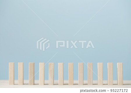 Domino block isolated pieces standing in a row on blue background. 93227172