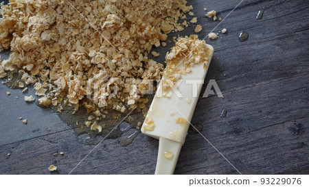 燕麥片加蜂蜜和一把烹飪工具的鏟子 燕麥片加蜂蜜和一把烹飪工具的鏟子 93229076