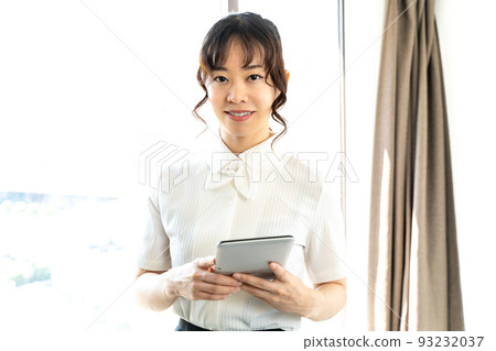 A woman watching a tablet A woman watching a tablet 93232037
