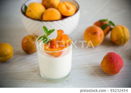 Healthy breakfast of homemade yogurt in a glass with fresh apricots Healthy breakfast of homemade yogurt in a glass with fresh apricots 93232454