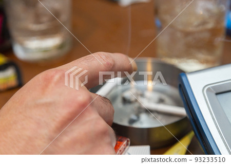 Hand of a man who smokes a cigarette with a snack 93233510