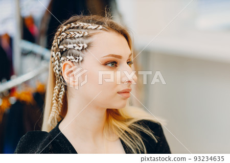 Hairstylist braided afro braids dreadlocks kanekalon pigtails hair of female client in barber salon. Hairstylist braided afro braids dreadlocks kanekalon pigtails hair of female client in barber salon. 93234635