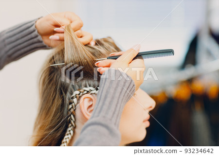 Hairstylist braided afro braids dreadlocks kanekalon pigtails hair of female client in barber salon. Hairstylist braided afro braids dreadlocks kanekalon pigtails hair of female client in barber salon. 93234642