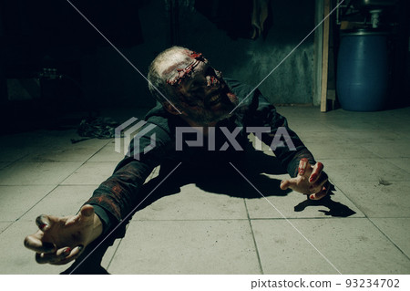 Zombie male creeps on floor halloween concept. Make up skin and blood face 93234702