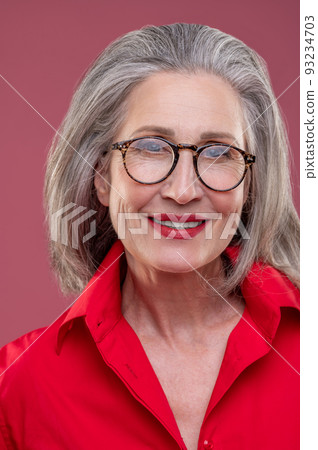 Mature woman in red shirt feeling cheerful Mature woman in red shirt feeling cheerful 93234703
