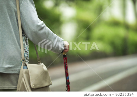 Back view of a senior woman with a cane 93235354
