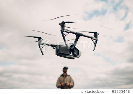 Man controlling fpv quadcopter drone for aerial photography and videography with goggles antenna remote controller. Man controlling fpv quadcopter drone for aerial photography and videography with goggles antenna remote controller. 93235448